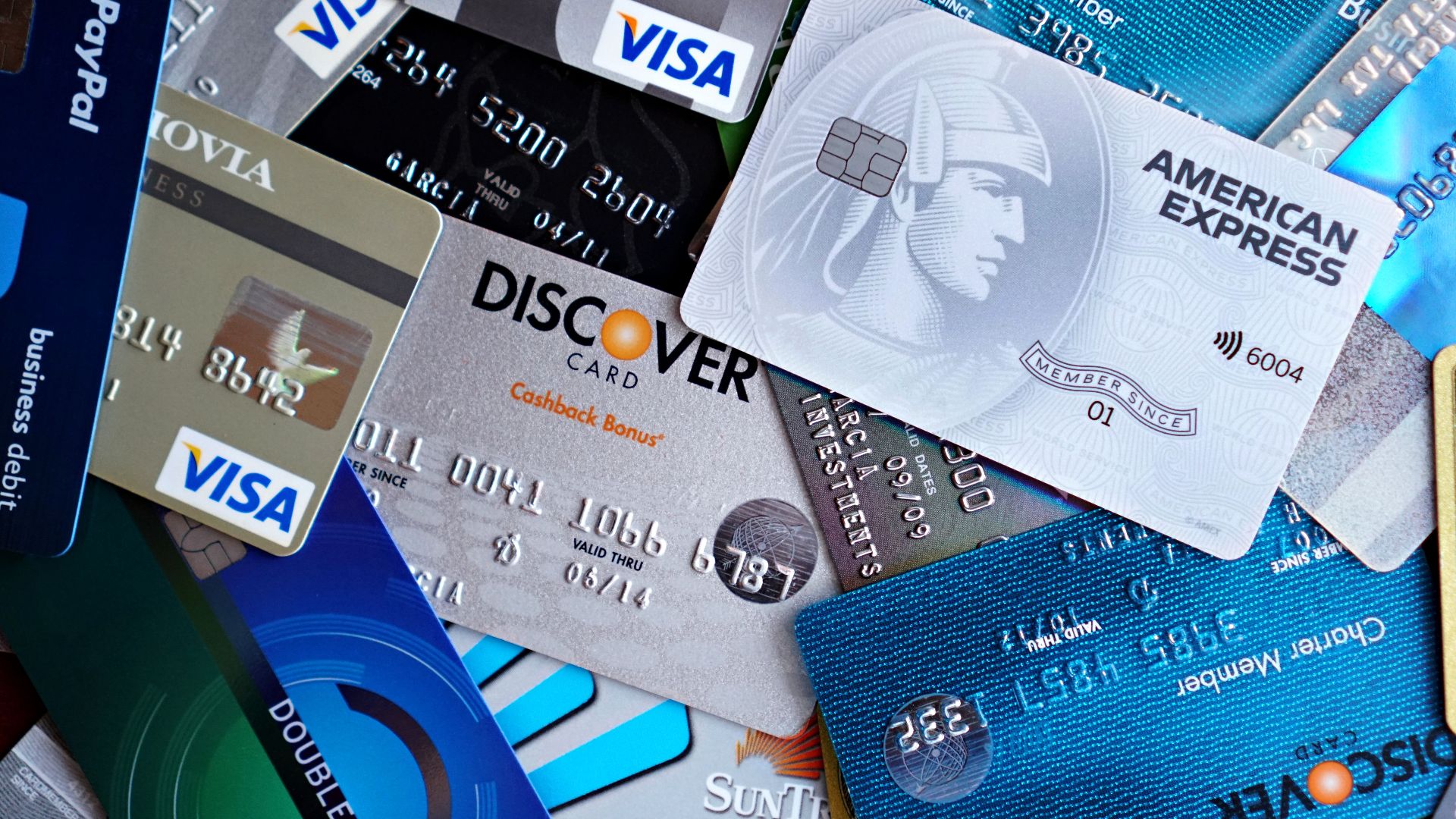 Close-up image of various credit cards including Visa, Mastercard, and American Express.