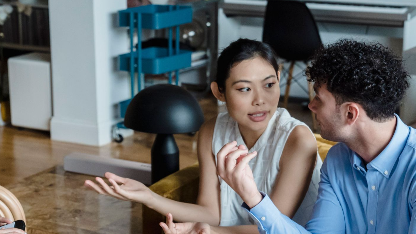 Couple having a discussion with a counselor in a modern living room setting.