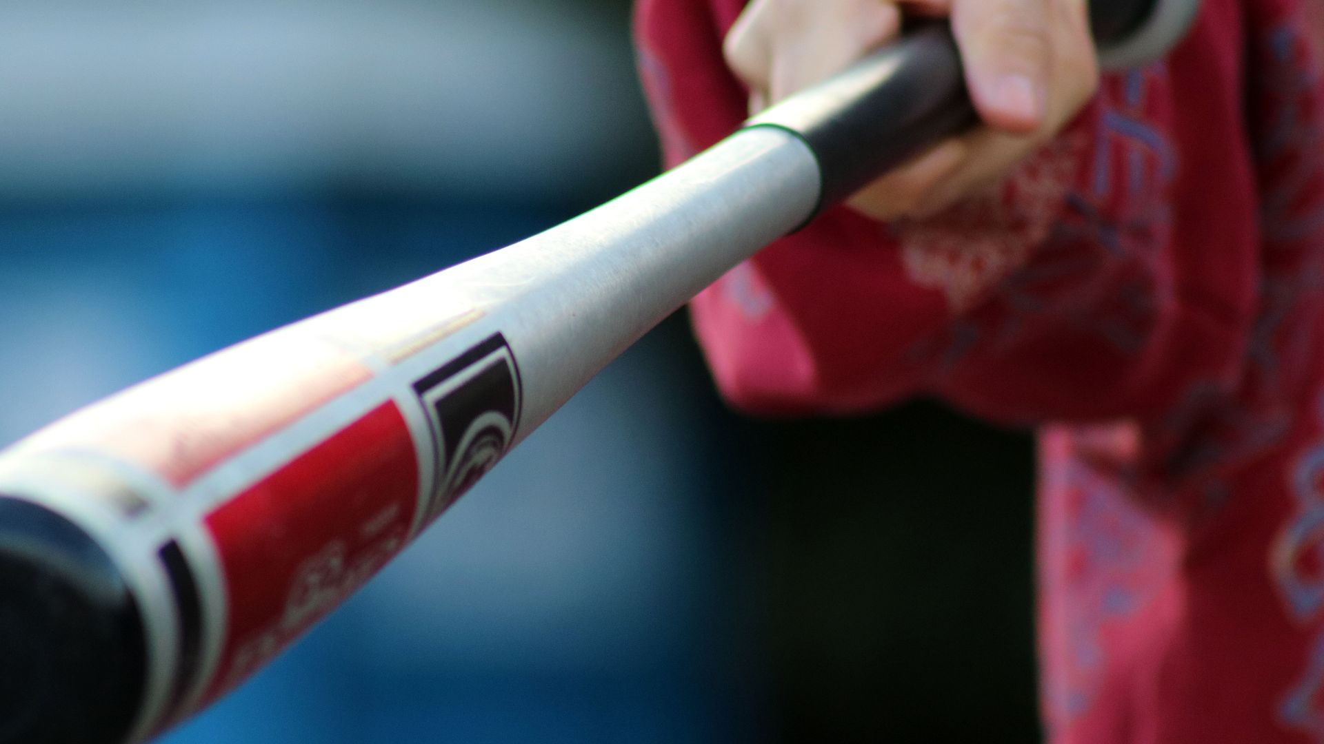 Close-up shot of a hand gripping a baseball bat, showcasing action and sports equipment.
