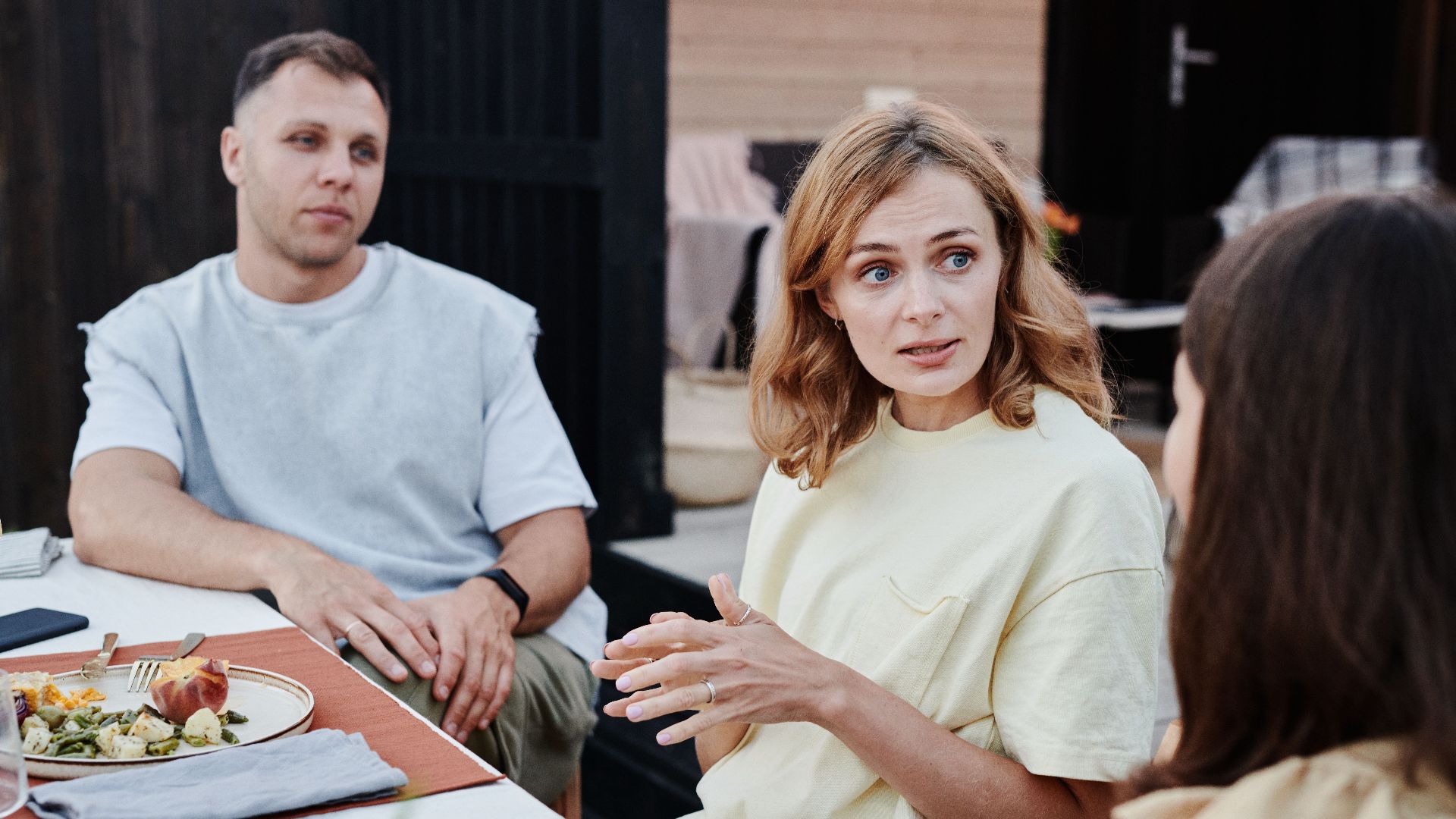A group of adults enjoying a relaxed outdoor meal together.