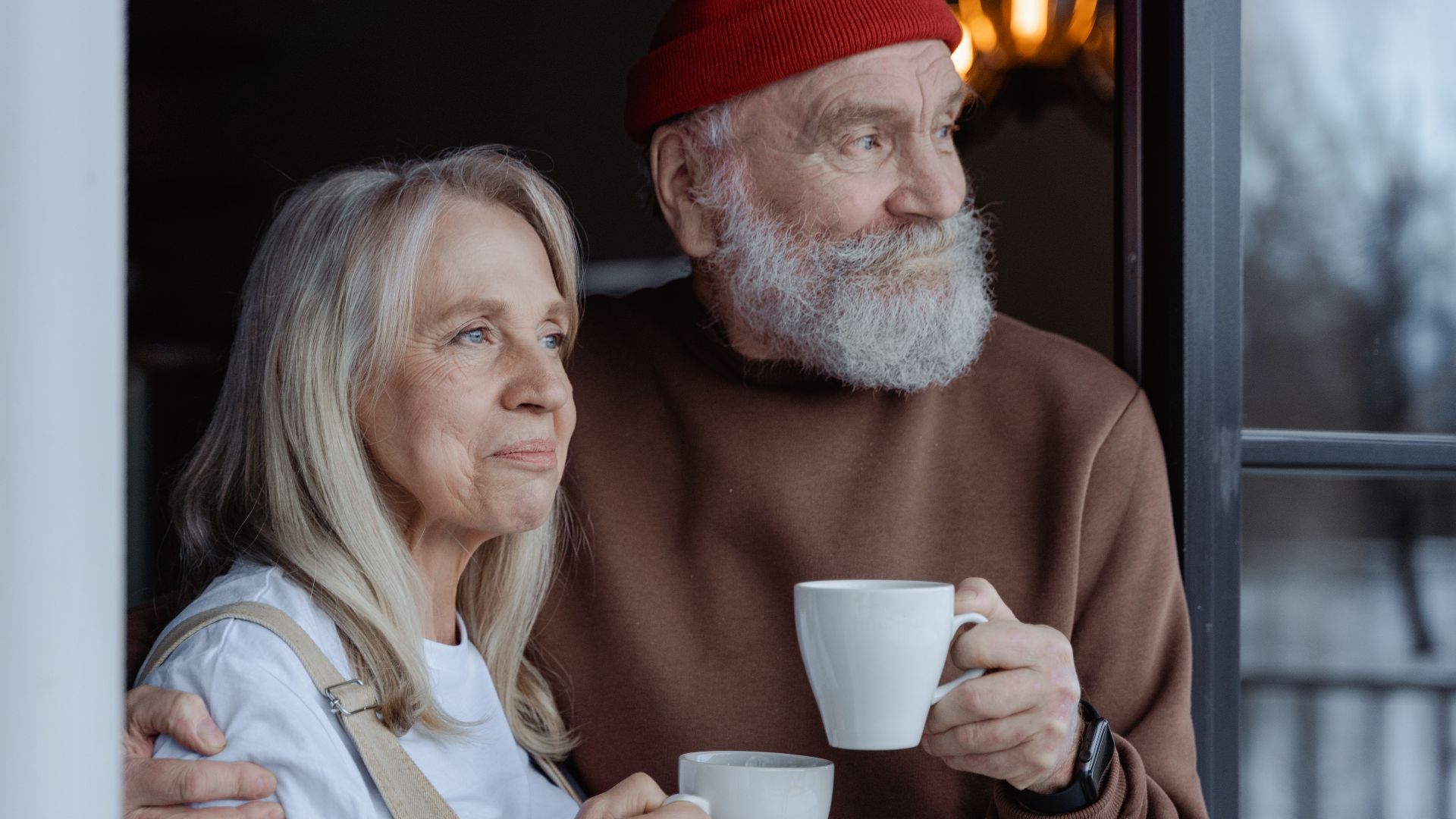A senior couple embraces while enjoying coffee, symbolizing love and companionship.