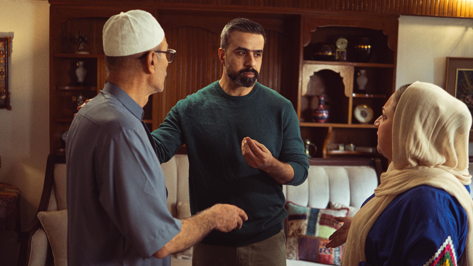 Three adults engage in a warm conversation in an inviting living room setting.