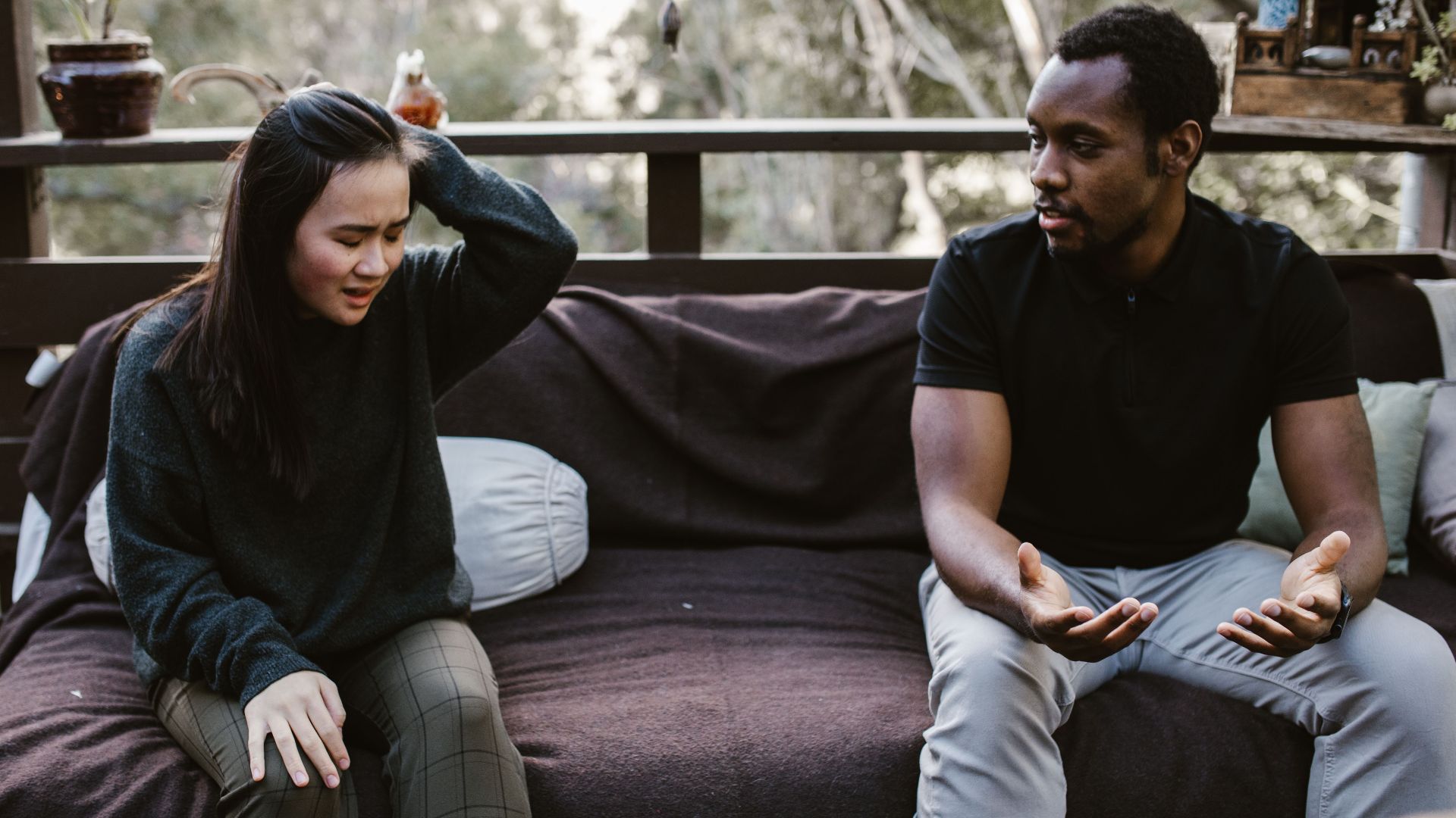Couple having an intense discussion outdoors. Emotionally charged moment captured.