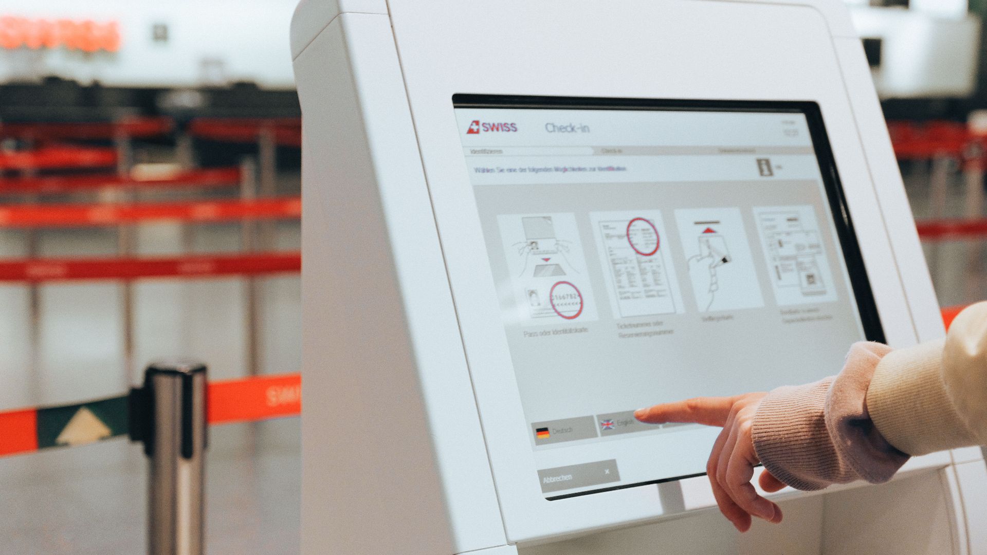 Passenger using self-service check-in kiosk at airport for convenient travel experience.
