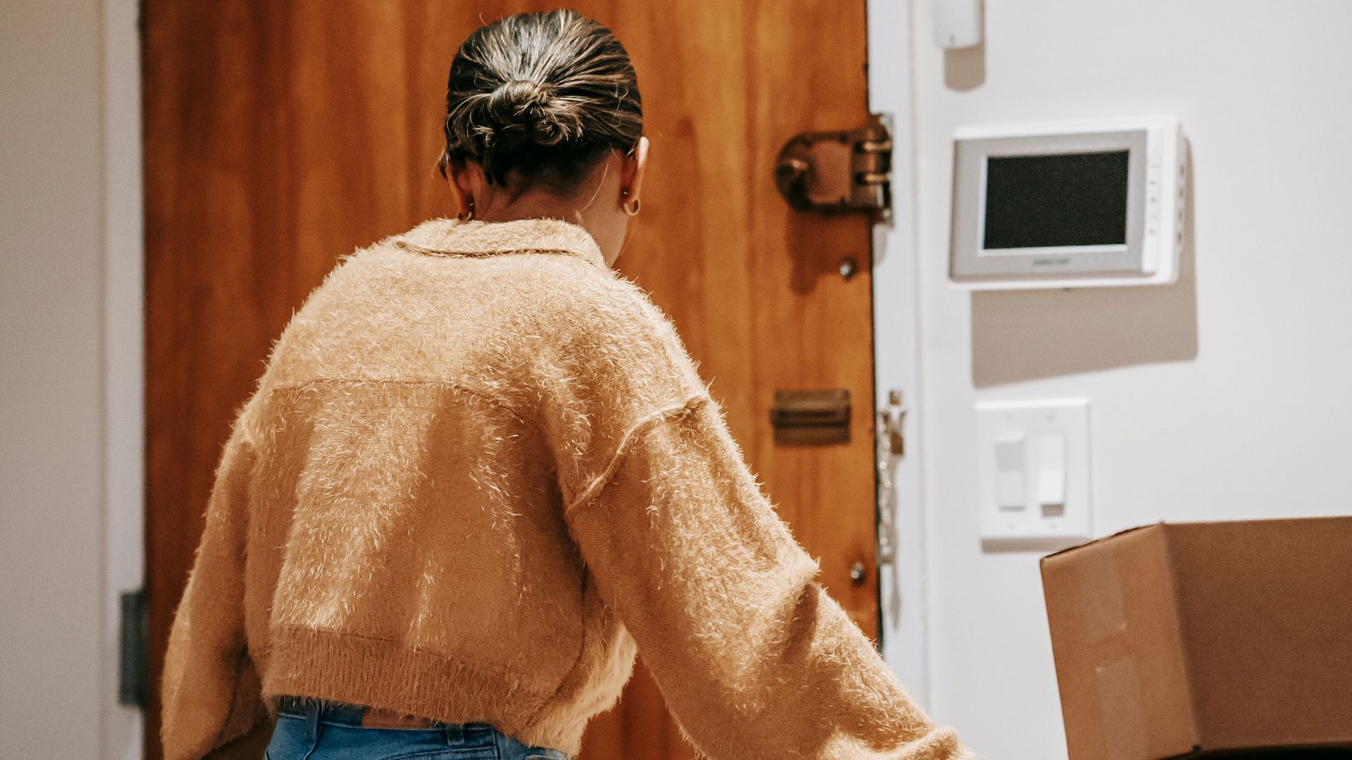 Back view of anonymous female in jeans taking shopping bag while preparing for delivering