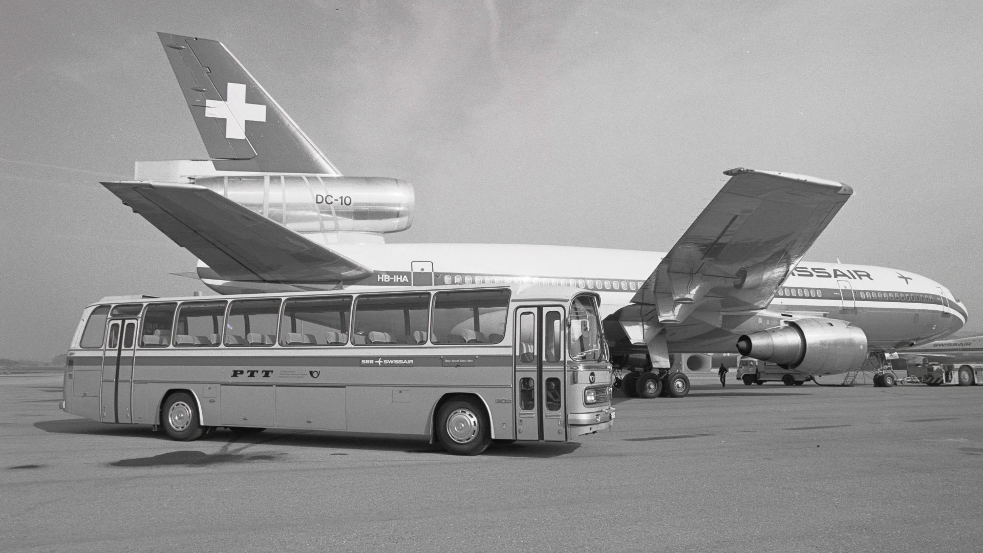 Postal bus Mercedes O 302-13R at Zürich-Kloten airport, in the background a Swissair DC-10.