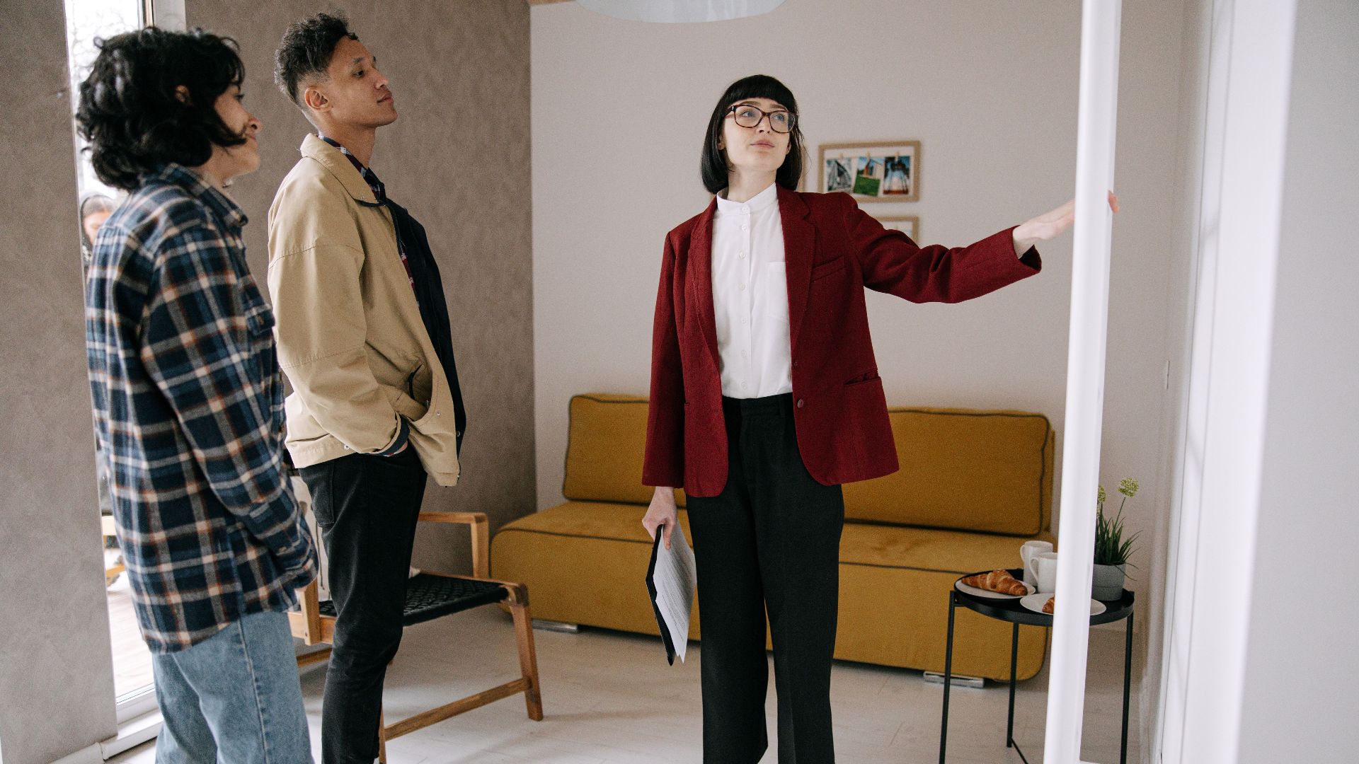 Realtor guiding potential buyers through a stylish apartment viewing.