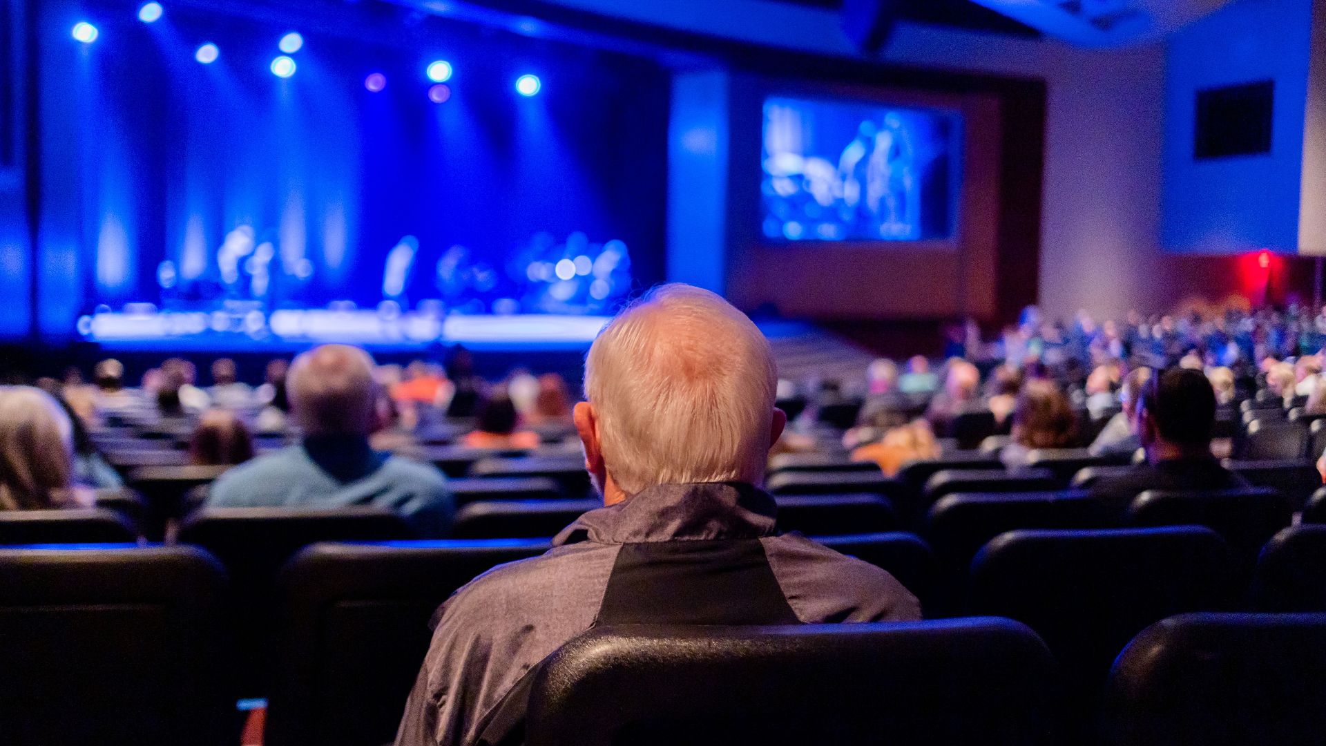 Audience seated in a theater watching a captivating live performance on stage.