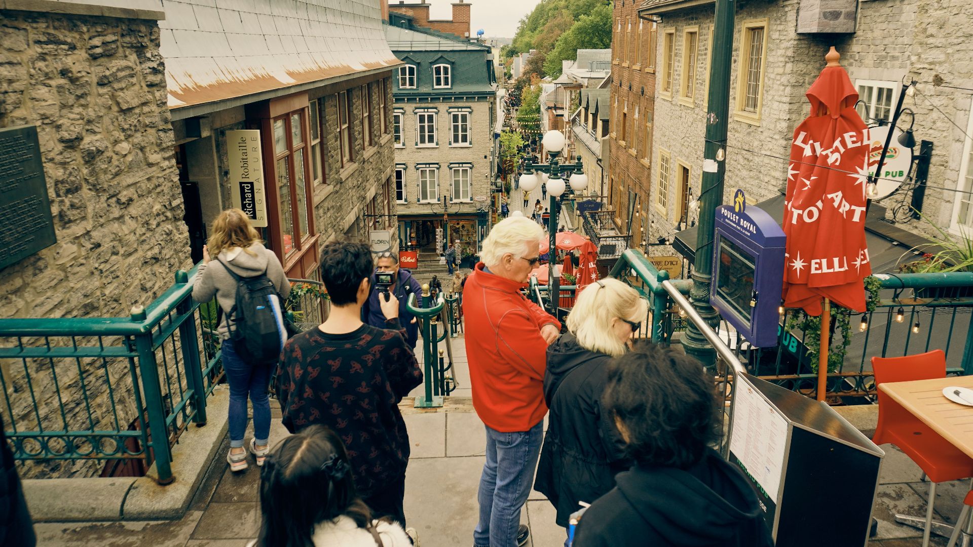 Tourists explore a historic street in Old Quebec, Canada, featuring charming architecture.