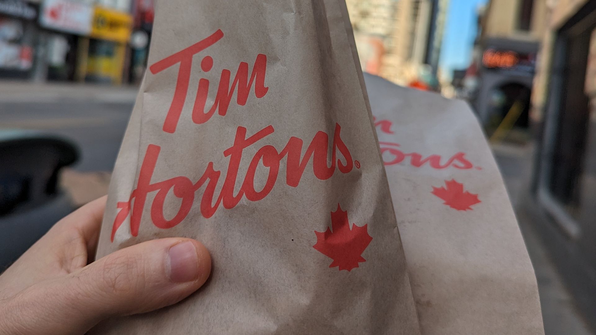 A bag of Tim Horton's pastries being carried along Yonge St. during WikiConference North America 2023.
