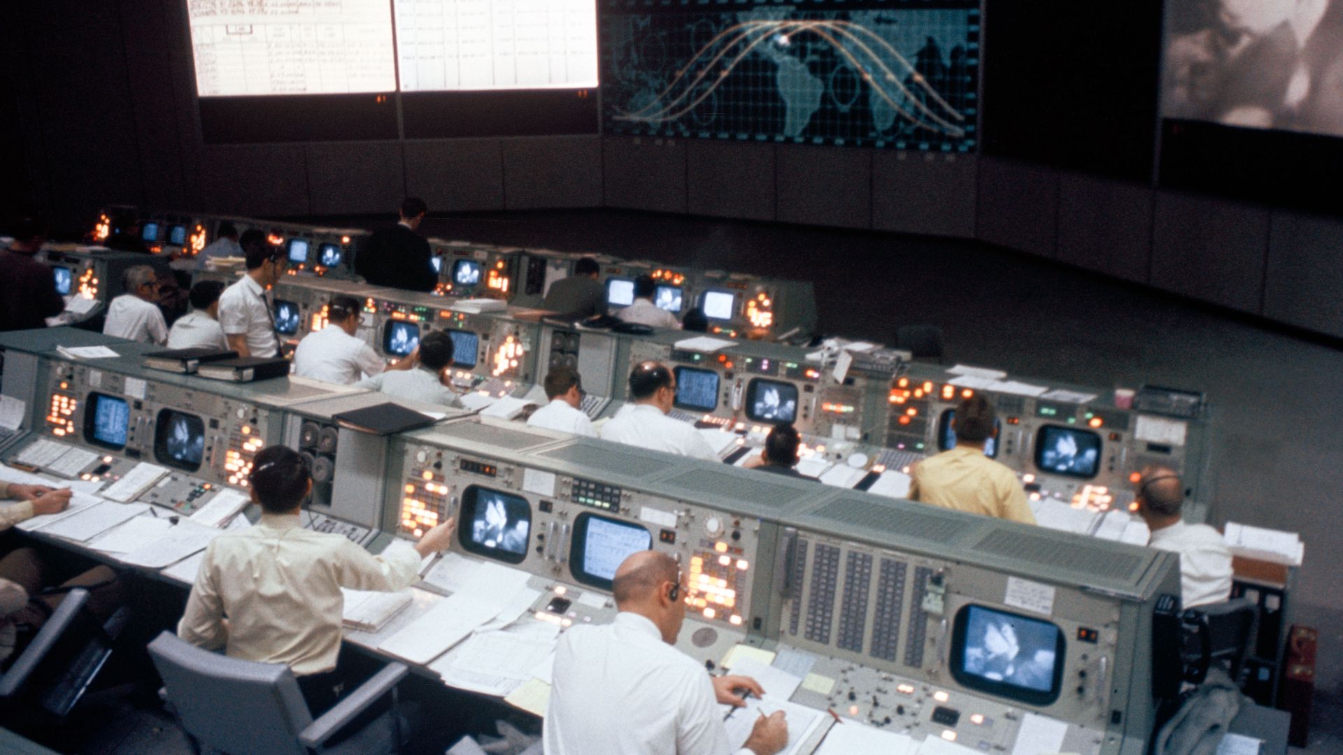 Overall view of the Mission Operations Control Room in the Mission Control Center, Building 30, during the Apollo 9 Earth-orbital mission. When this photograph was taken a live television transmission was being received from Apollo 9 as it orbited Earth.