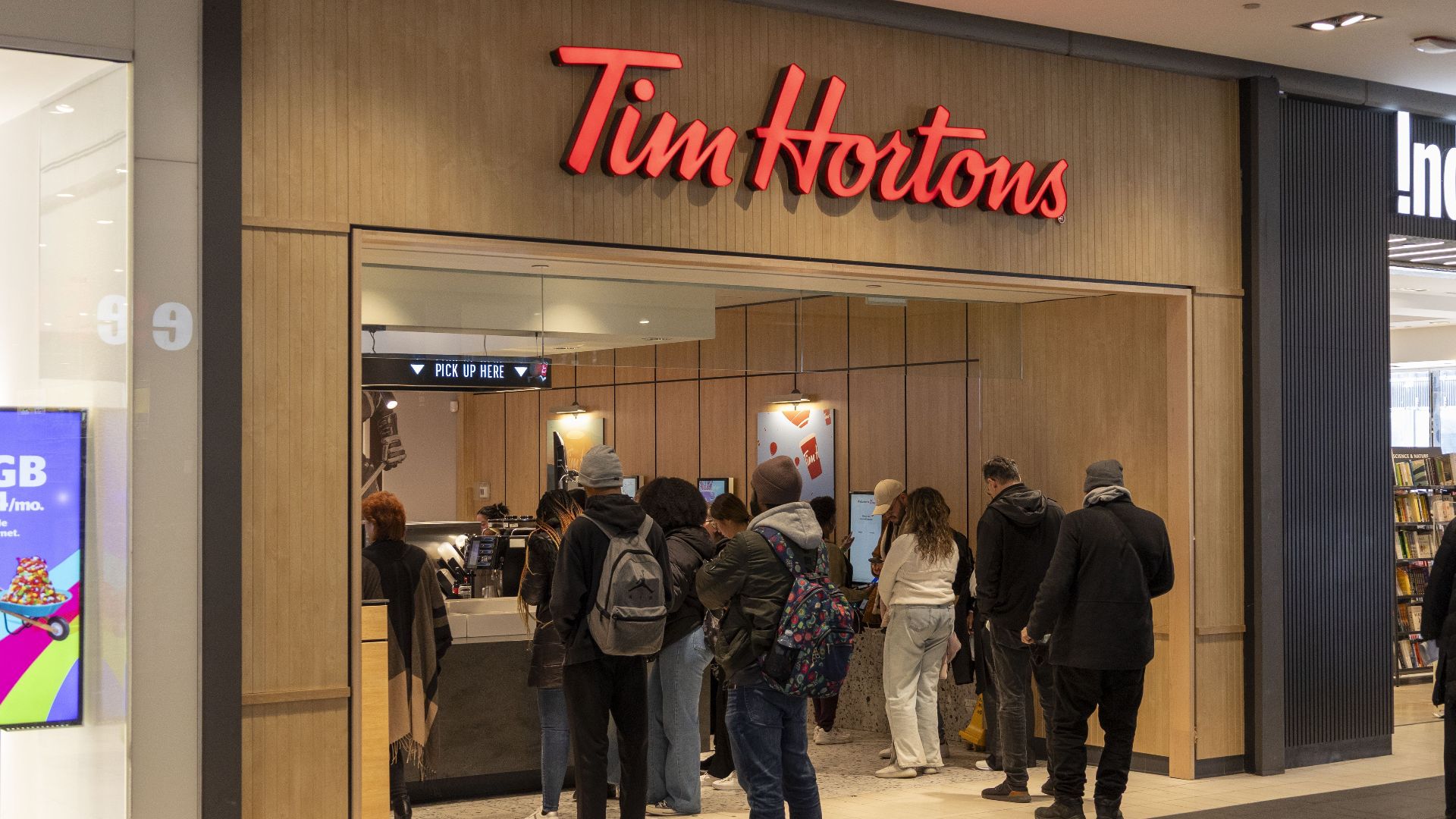 Busy Tim Hortons with customers waiting in line at the counter.