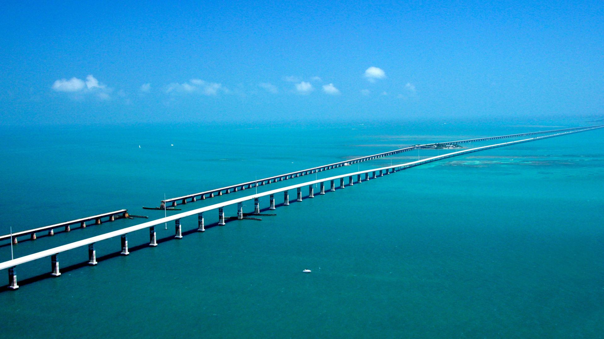 Seeming to converge in the distance, the Seven-mile Bridge on the Florida Keys Scenic Highway west of Marathon, FL, runs parallel to the historic Flagler railroad bridge of the early 1900s with the Atlantic Ocean to the South and the Gulf of Mexico to the