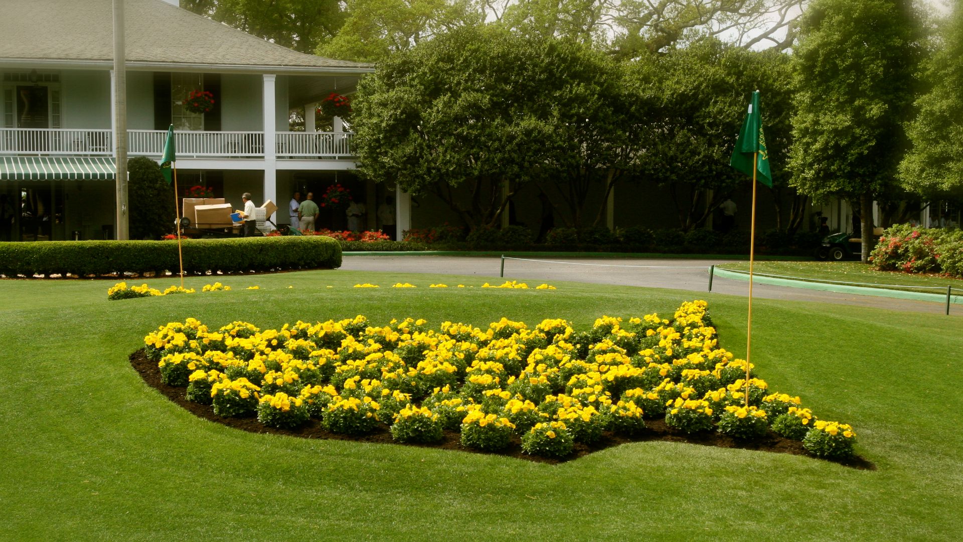 The logo for the Masters Tournament made of flowers, in front of the clubhouse of the Augusta National Golf Club.
