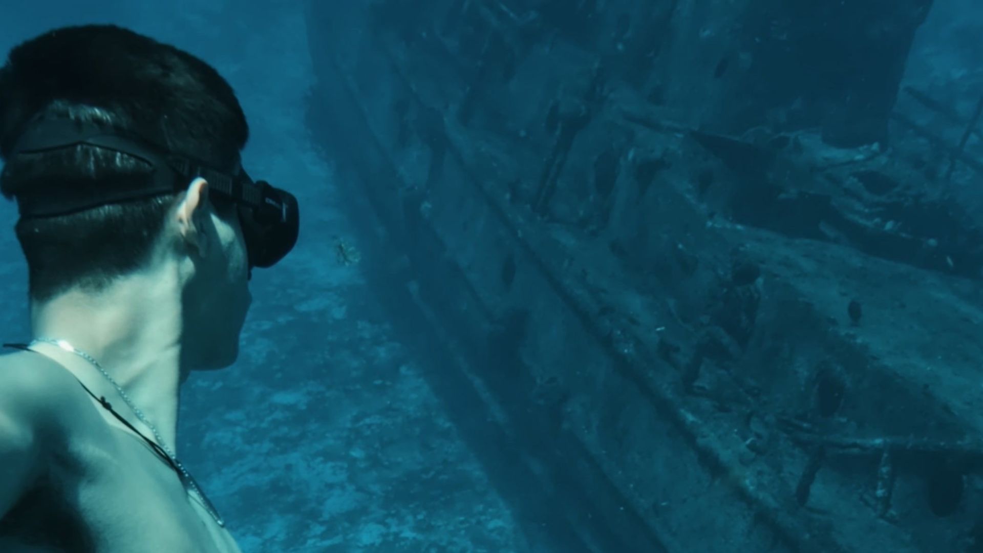 Explore the underwater world with a diver near a mysterious shipwreck.
