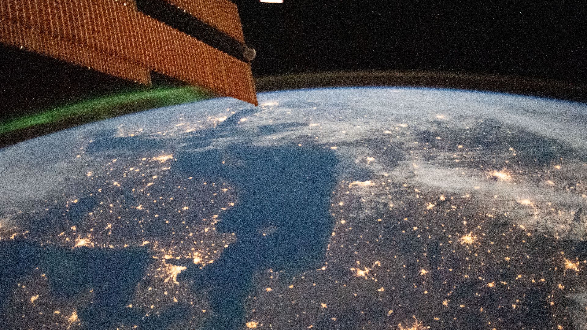 A faint aurora and the Earth's atmospheric glow crown this night time photograph of Northern Europe, as the International Space Station orbited 262 miles above. Prominent city lights include those of (from right to left) Berlin, Germany; Copenhagen, Denma