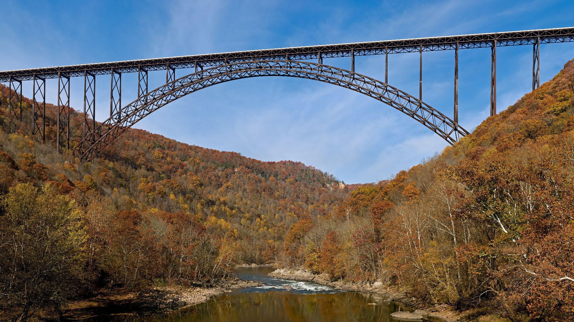 The New River Gorge Bridge in Fayetteville, West Virginia is a steel arch bridge that carries US 19 over the New River. It opened in 1977 and is the longest and highest steel arch bridge in the Western Hemisphere at 3030 ft (924 m) long and 876 ft (267 m)
