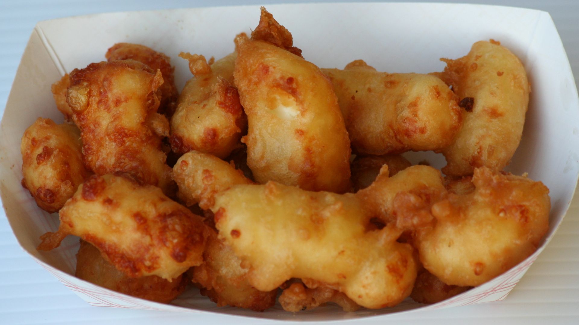 Cheese curds covered in beer batter and then deep fried in oil, served at an outdoor food booth at the Gopher Count community festival in Viola, Minnesota