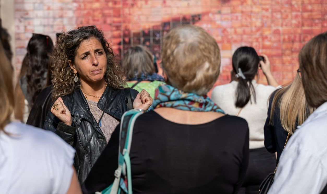 Barcelona, Spain - November 12, 2025:Female tour guide explaining the famous Kiss Mural to tourists in Barcelona, Spain