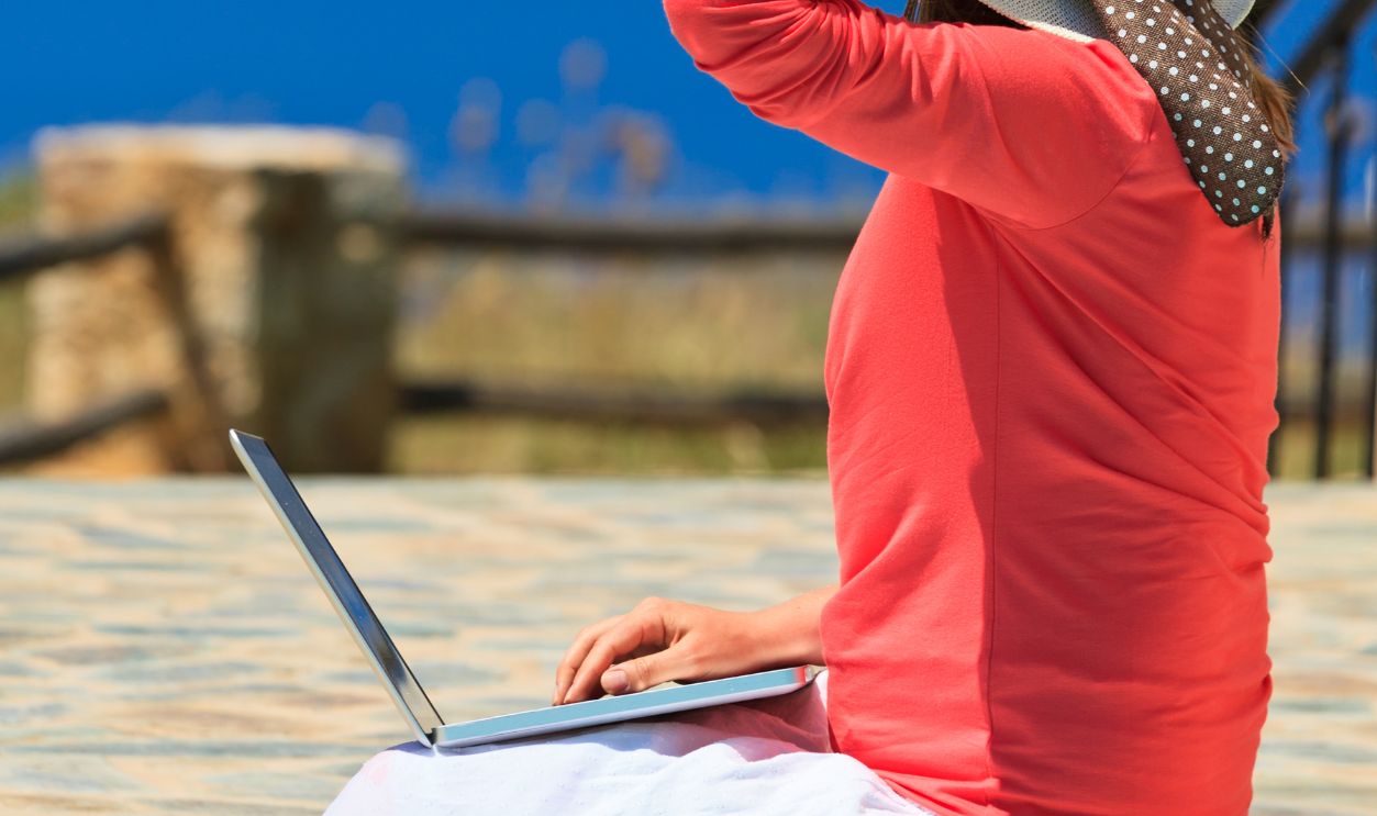 young woman with laptop on vacation