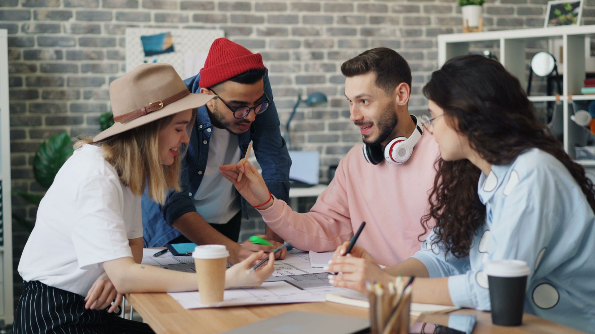 Young diverse team brainstorming together in a modern office setting, promoting teamwork and innovation.