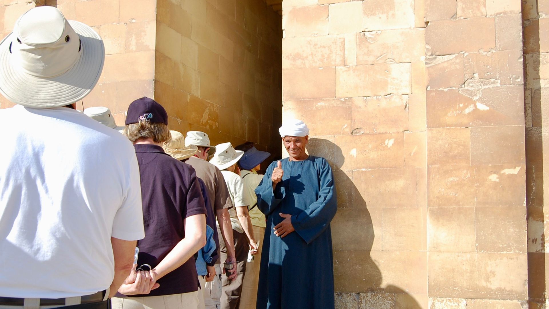 A local guide gives a thumbs up to tourists at a historic site in Cairo, Egypt.