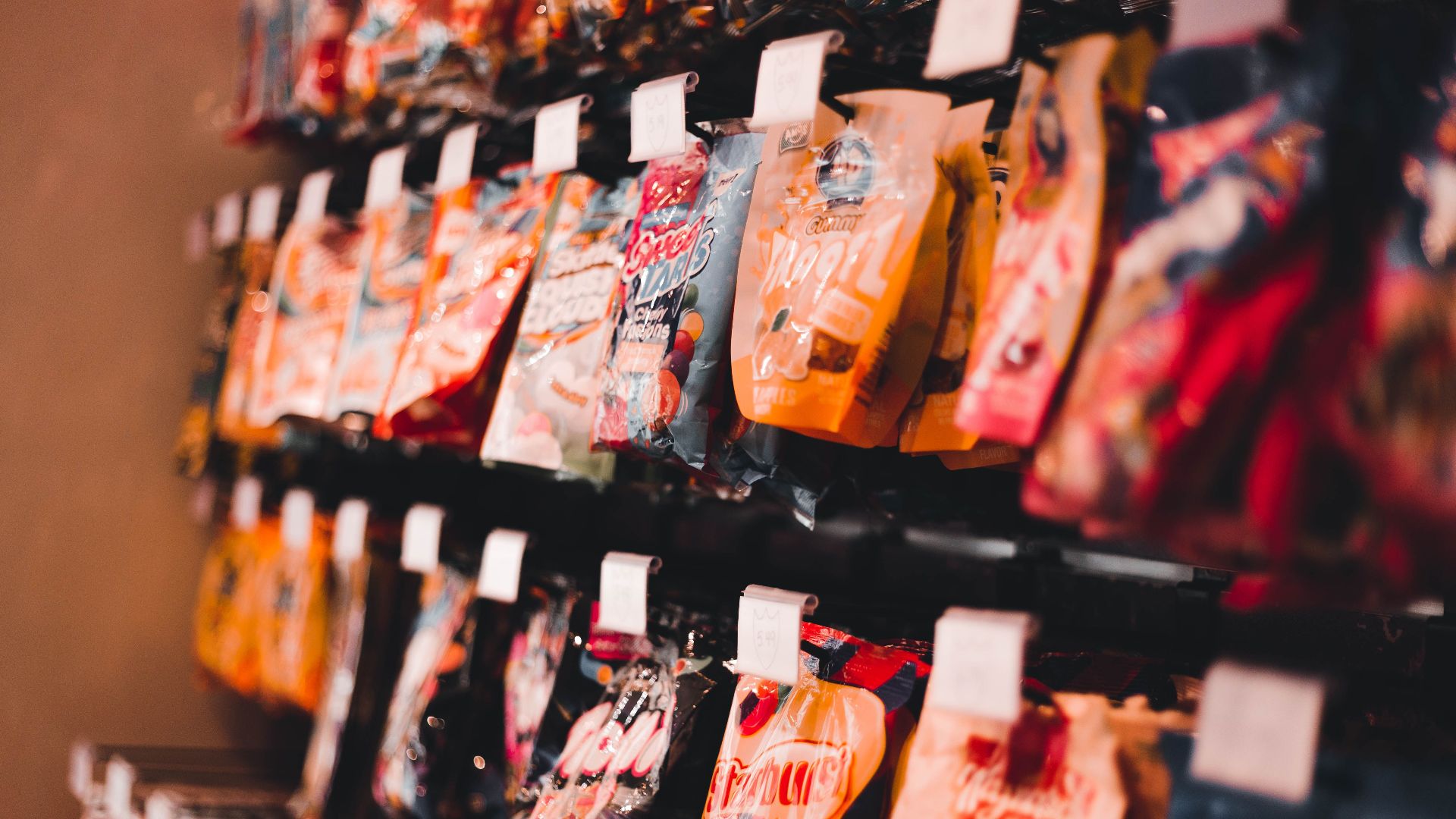 A vibrant display of assorted candy packets on a store shelf, perfect for marketing or retail content.
