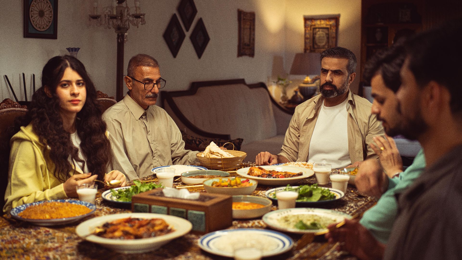 A family gathers at home for a traditional dinner, sharing diverse dishes and warm company.