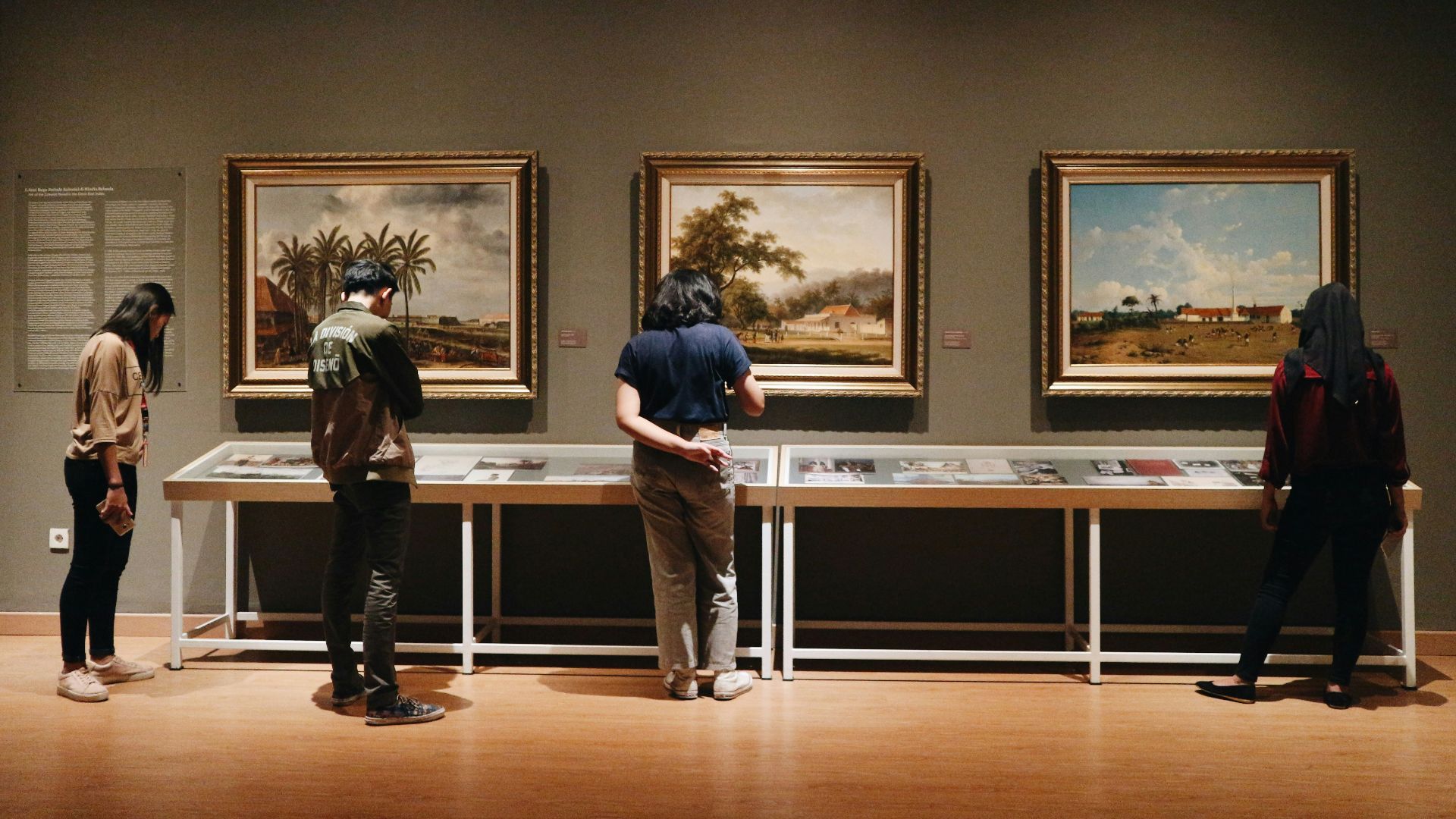people standing in front of paintings