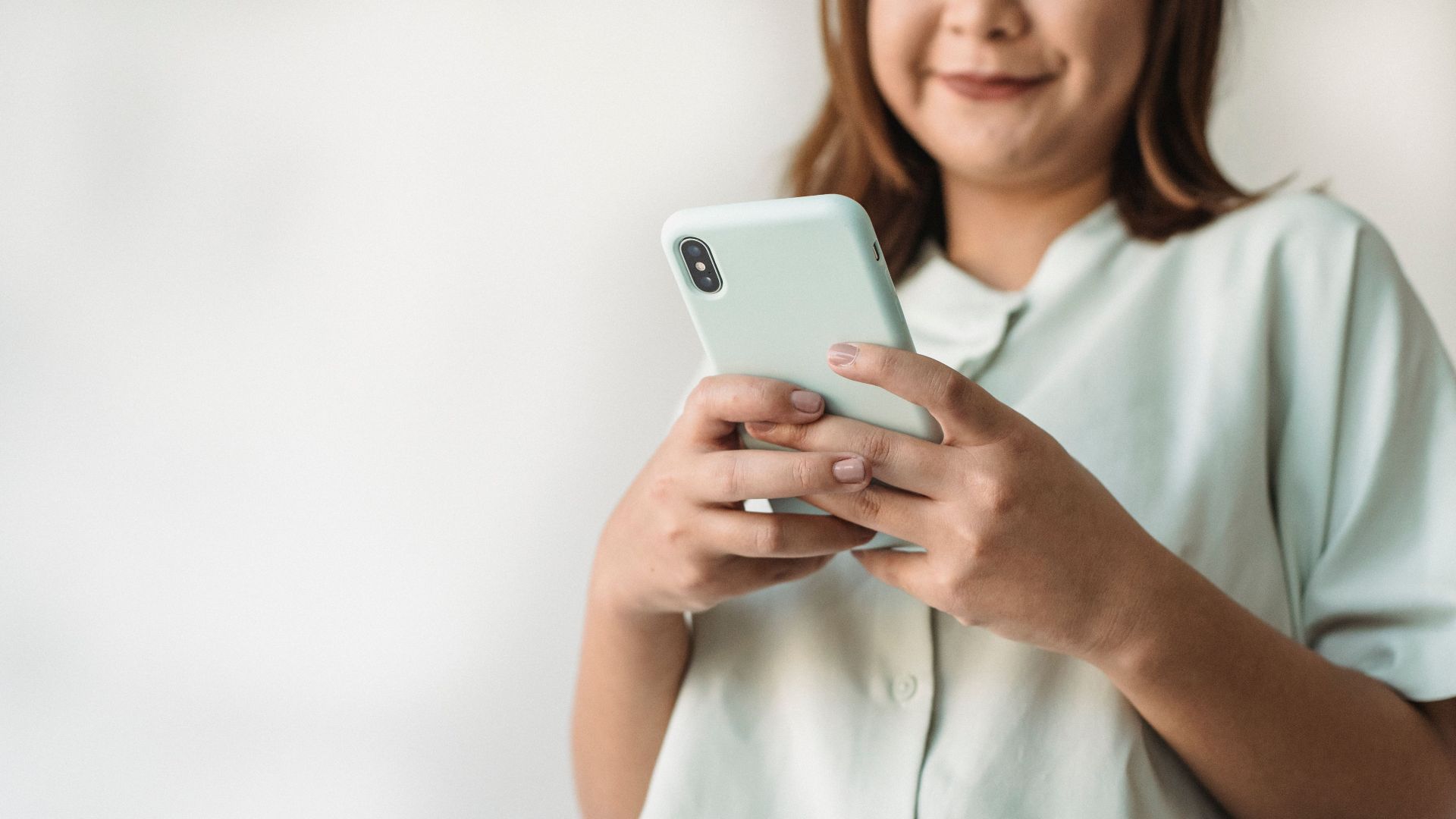 Close-up of a woman using a smartphone indoors with ample copy space.