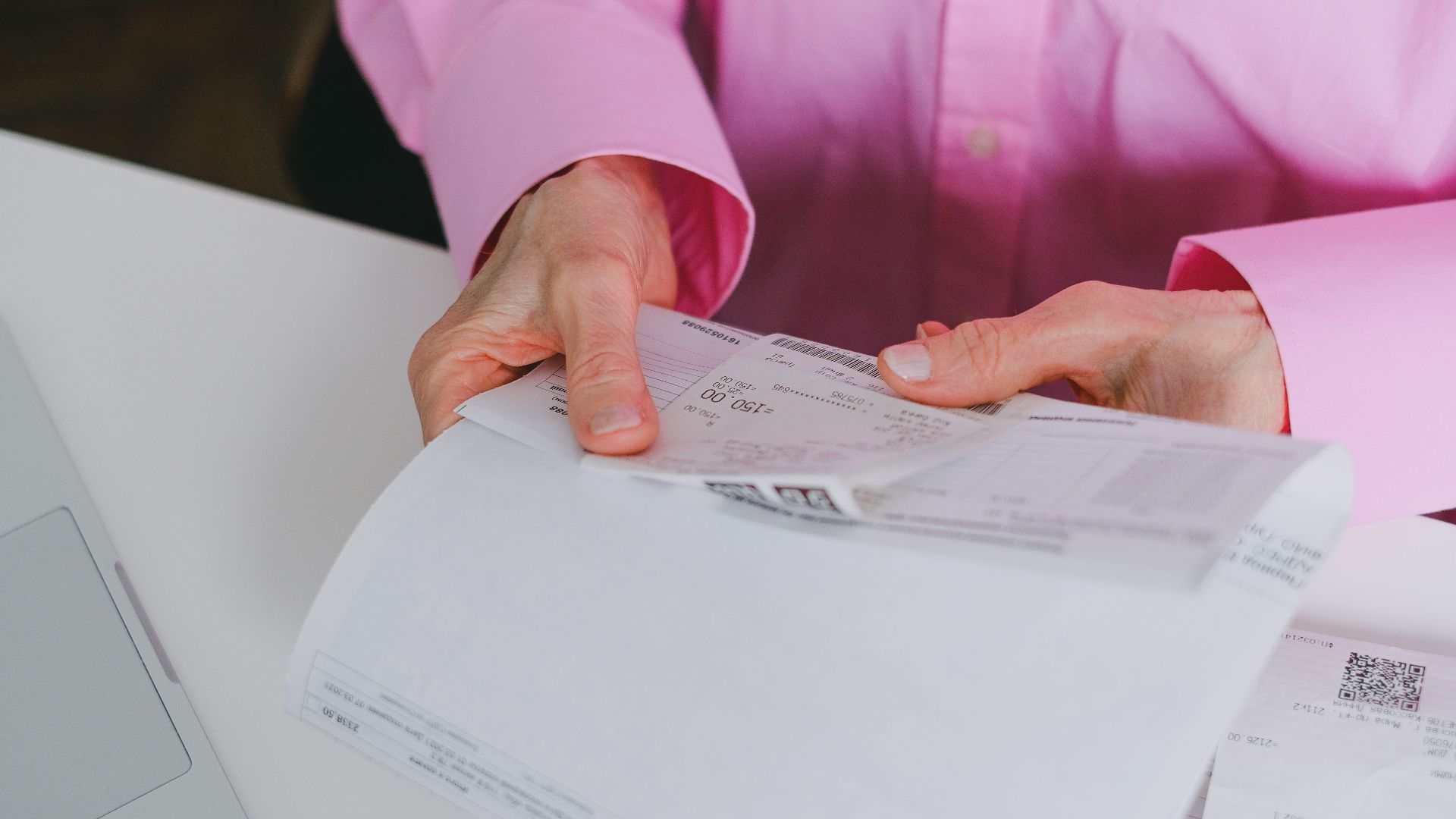 Business person handling paper receipts, meticulously organized.