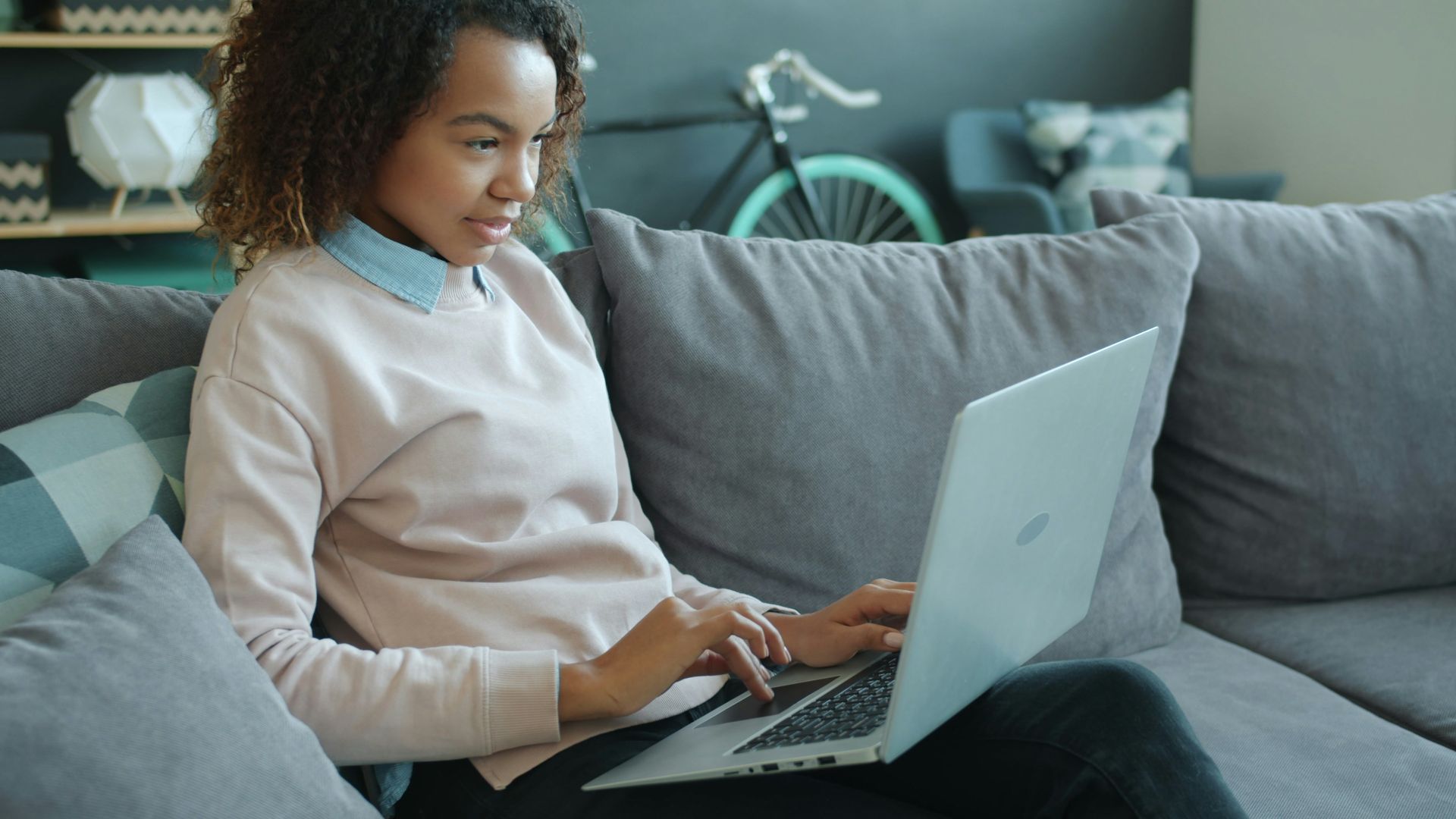 Woman working on a laptop on a couch