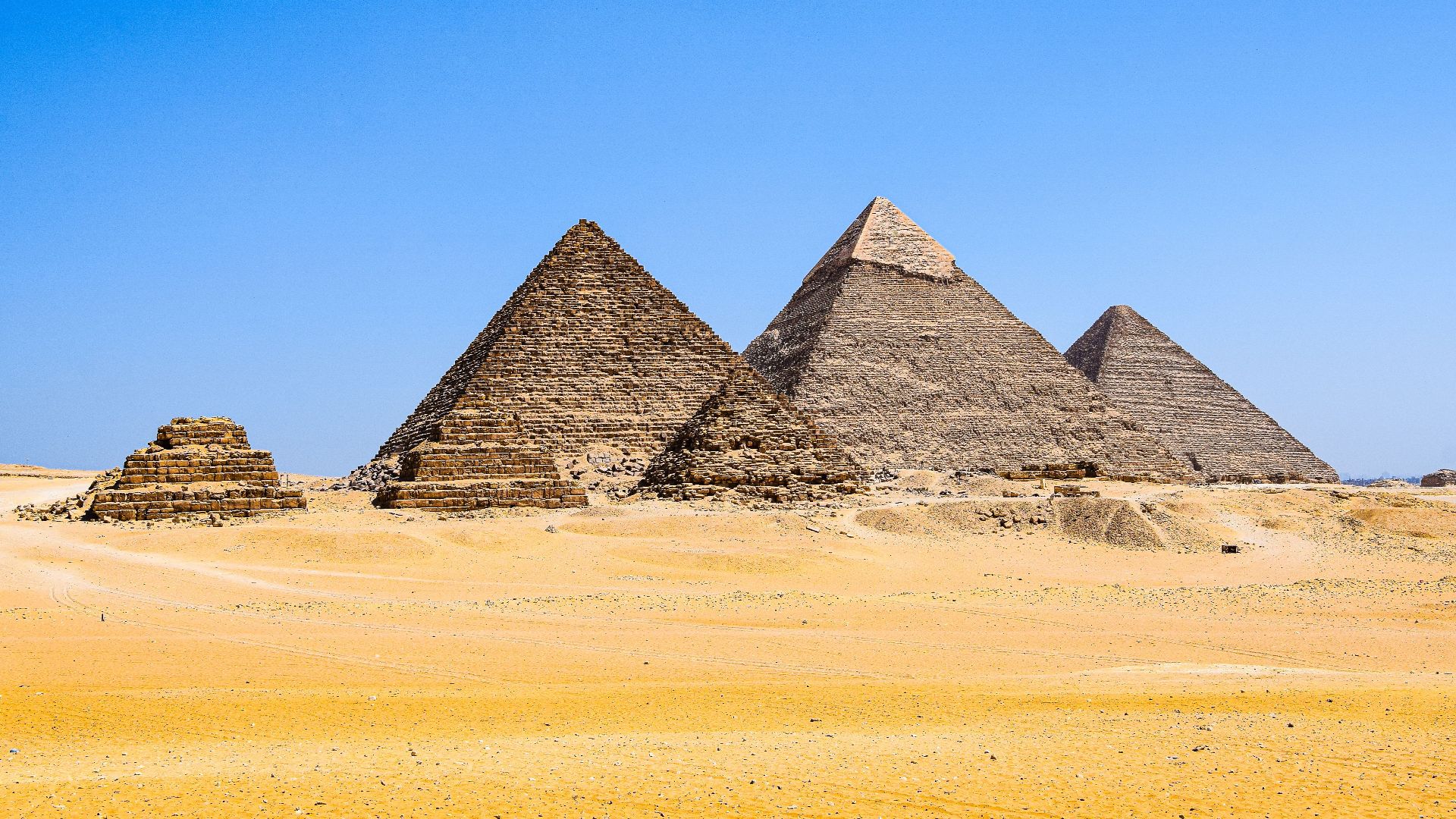 Explore the ancient Pyramids of Giza against a stunning blue sky and golden desert sands.