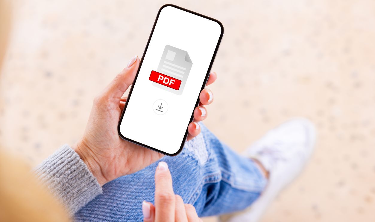 Person holding mobile phone with  PDF file icon on the screen