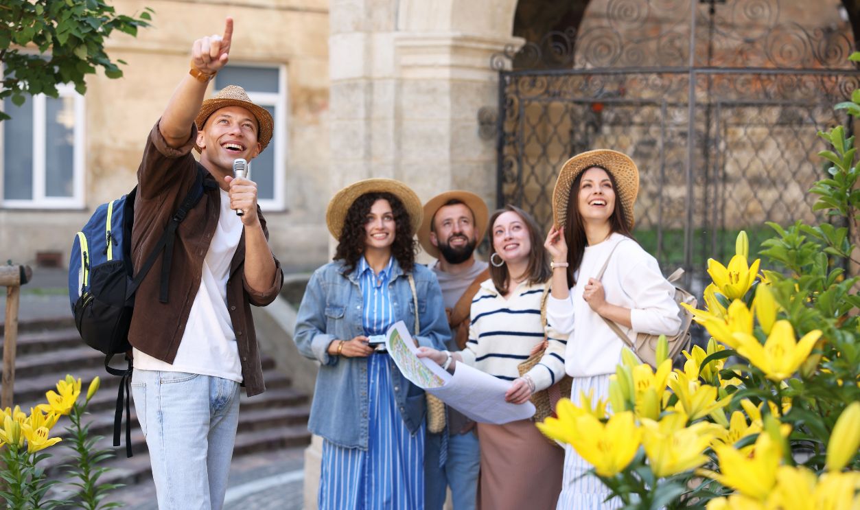 Guide with microphone and group of tourists on city street during excursion