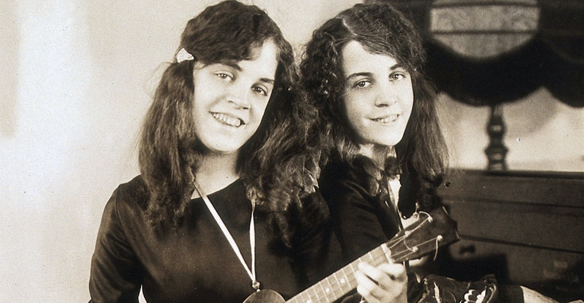 Daisy and Violet Hilton, conjoined twins, playing piano and ukelele. Photograph, c. 1927.Iconographic Collections