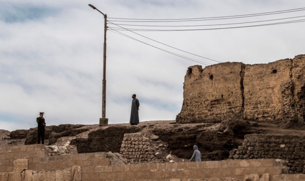 An Egyptian policeman (L) speaks on a radio transciever while on guard at the New Kingdom period (16th-11th centuries BC) Temple of Seti I, at the archaeological site of Abydos near Egypt's southern city of Sohag, about 540 kilometres from the capital Cairo, on April 5, 2019.