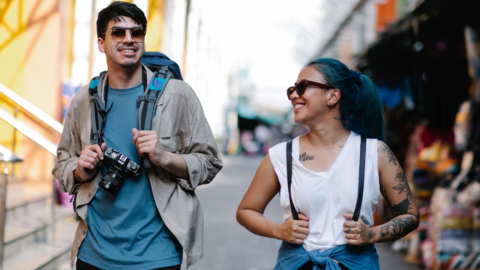 A cheerful couple with backpacks enjoying sightseeing during their travel adventure.