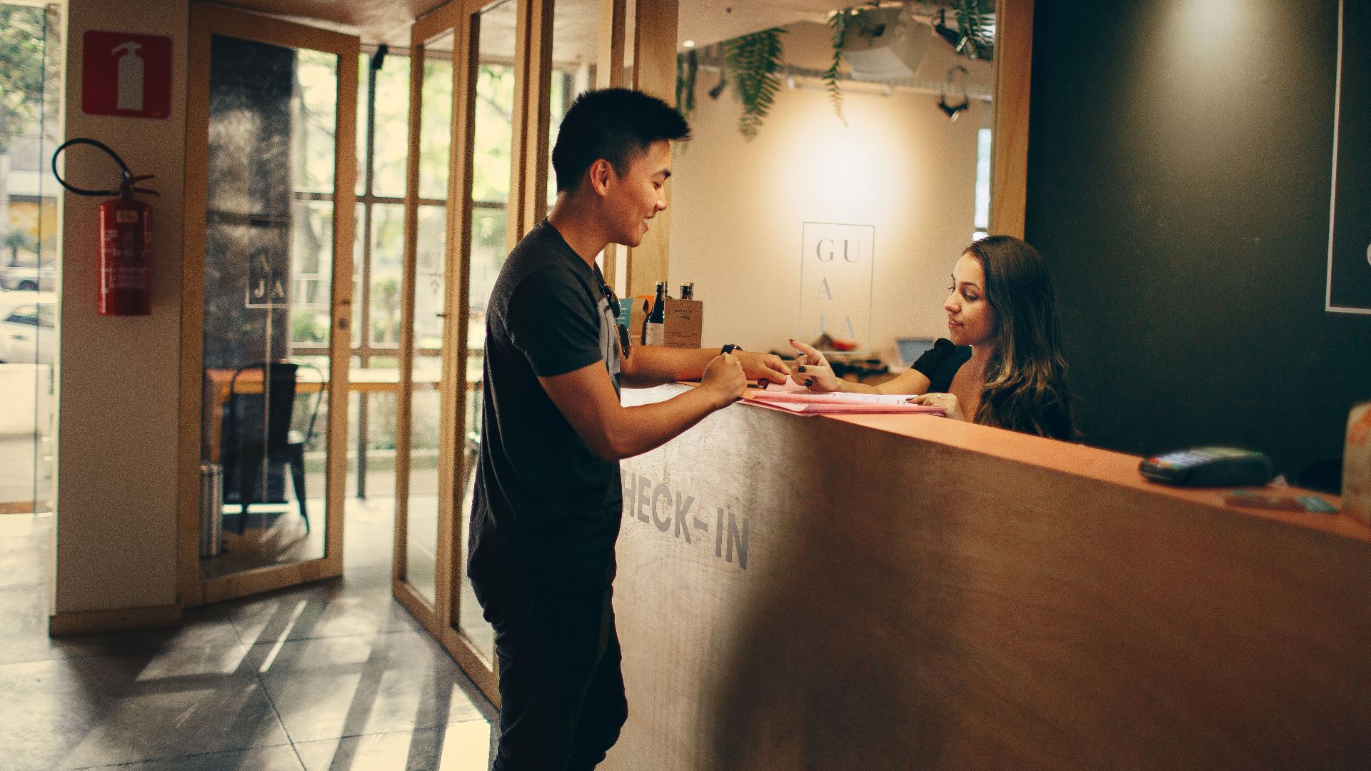 A customer checks in at a hotel reception desk in Belo Horizonte, Brazil.