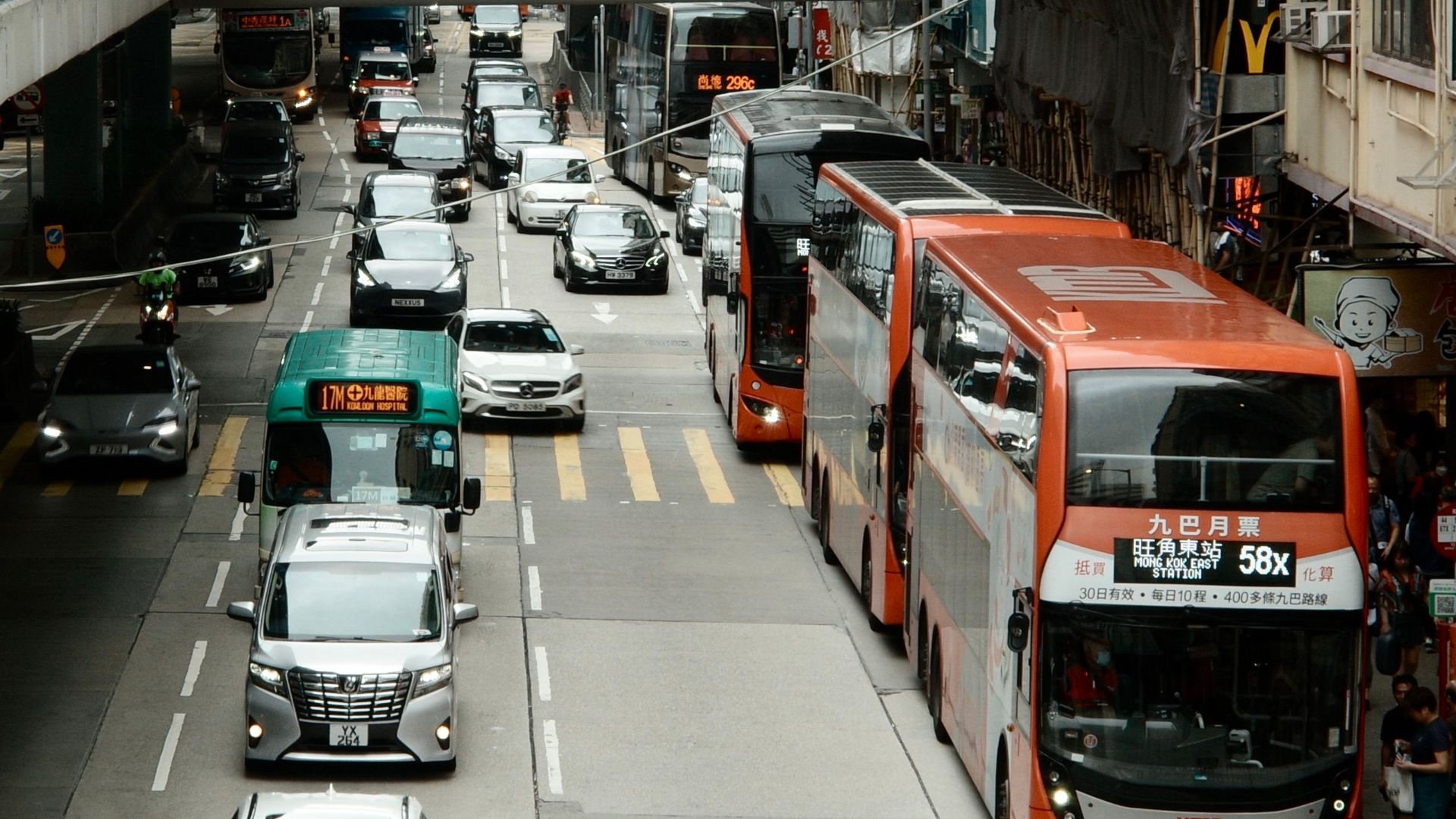 Busy Hong Kong street scene featuring double-decker buses and urban traffic on a typical city day.