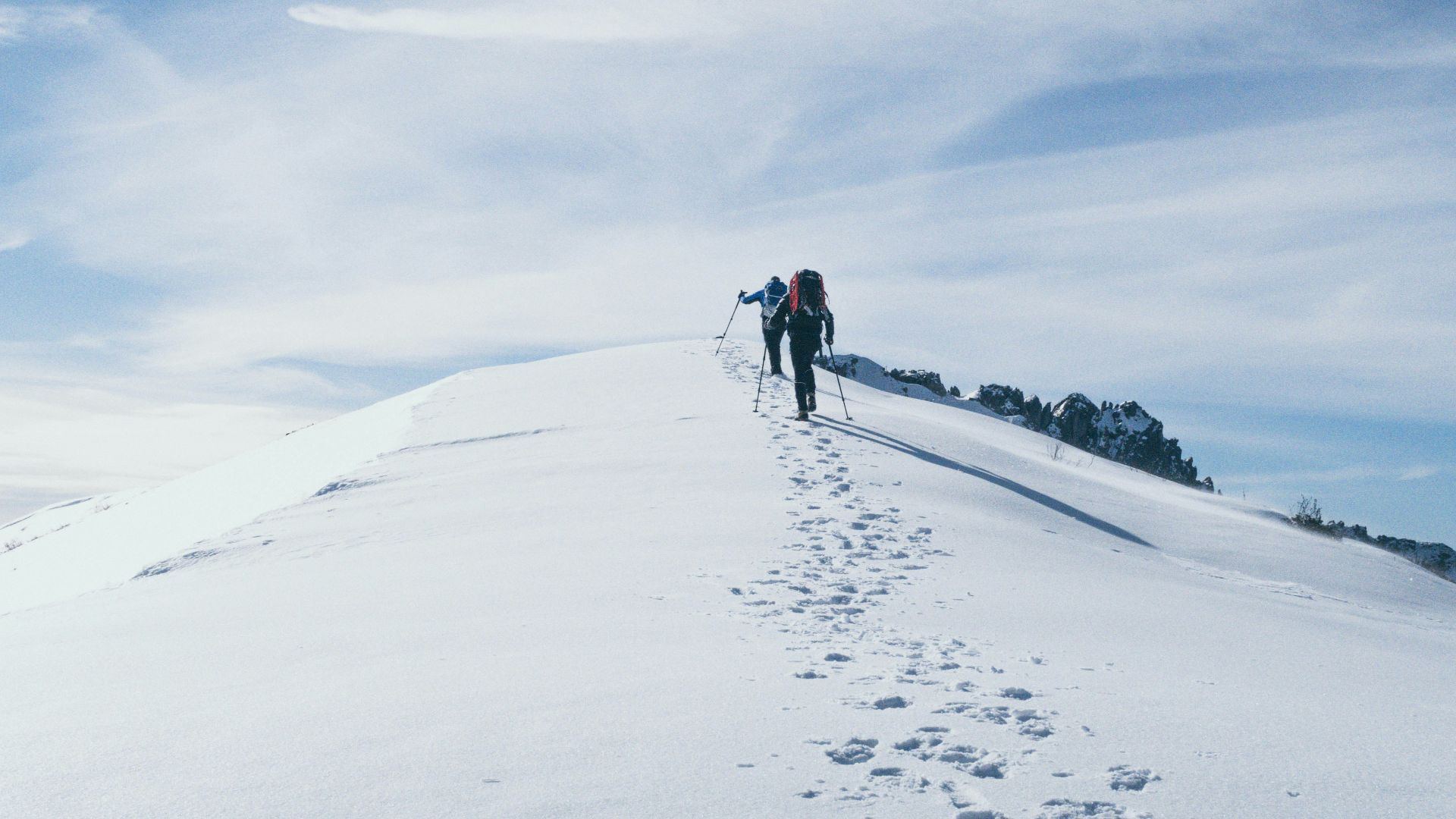 two person climbing on mountain covered snow