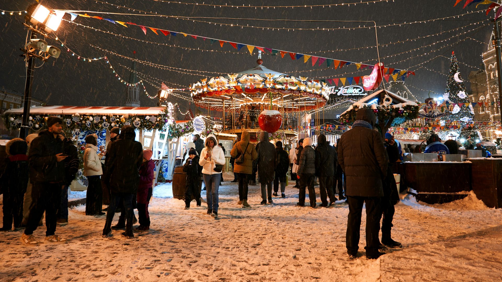 a crowd of people standing around a carnival at night