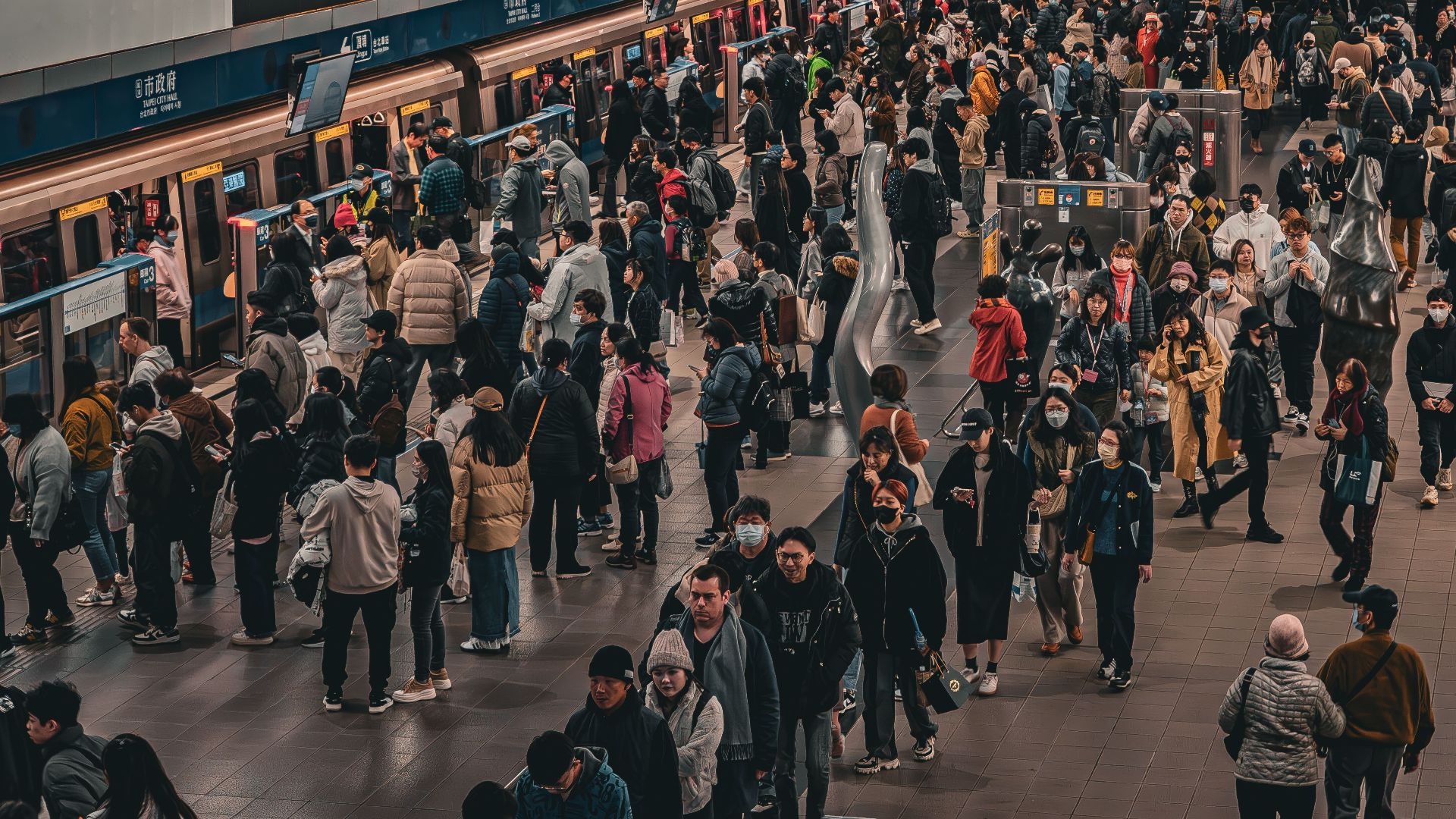 Overhead view of a bustling crowd at a metro station platform in Taipei, Taiwan.