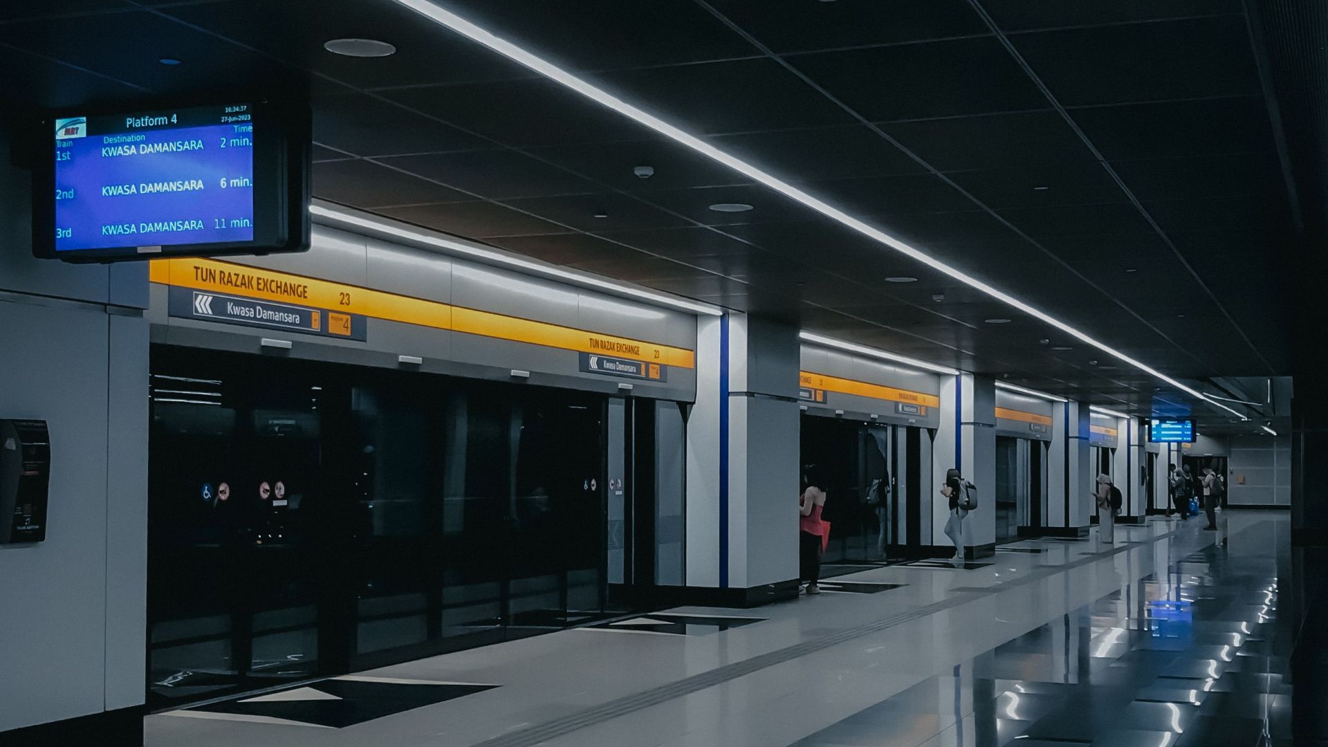 A dimly illuminated metro station in Kuala Lumpur, showcasing modern design and urban architecture.