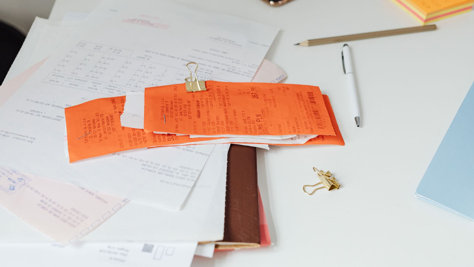 Close-up of a tidy desk with receipts, documents, and office stationery for business organization.