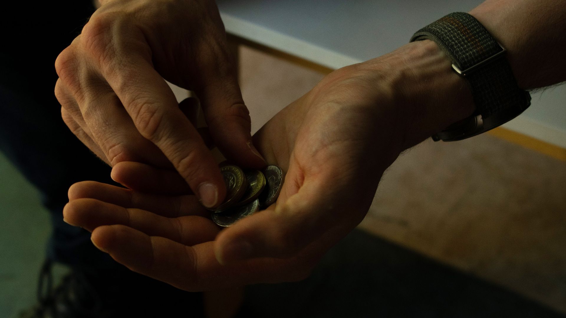Close-up of hands counting coins, implying budgeting or financial planning.