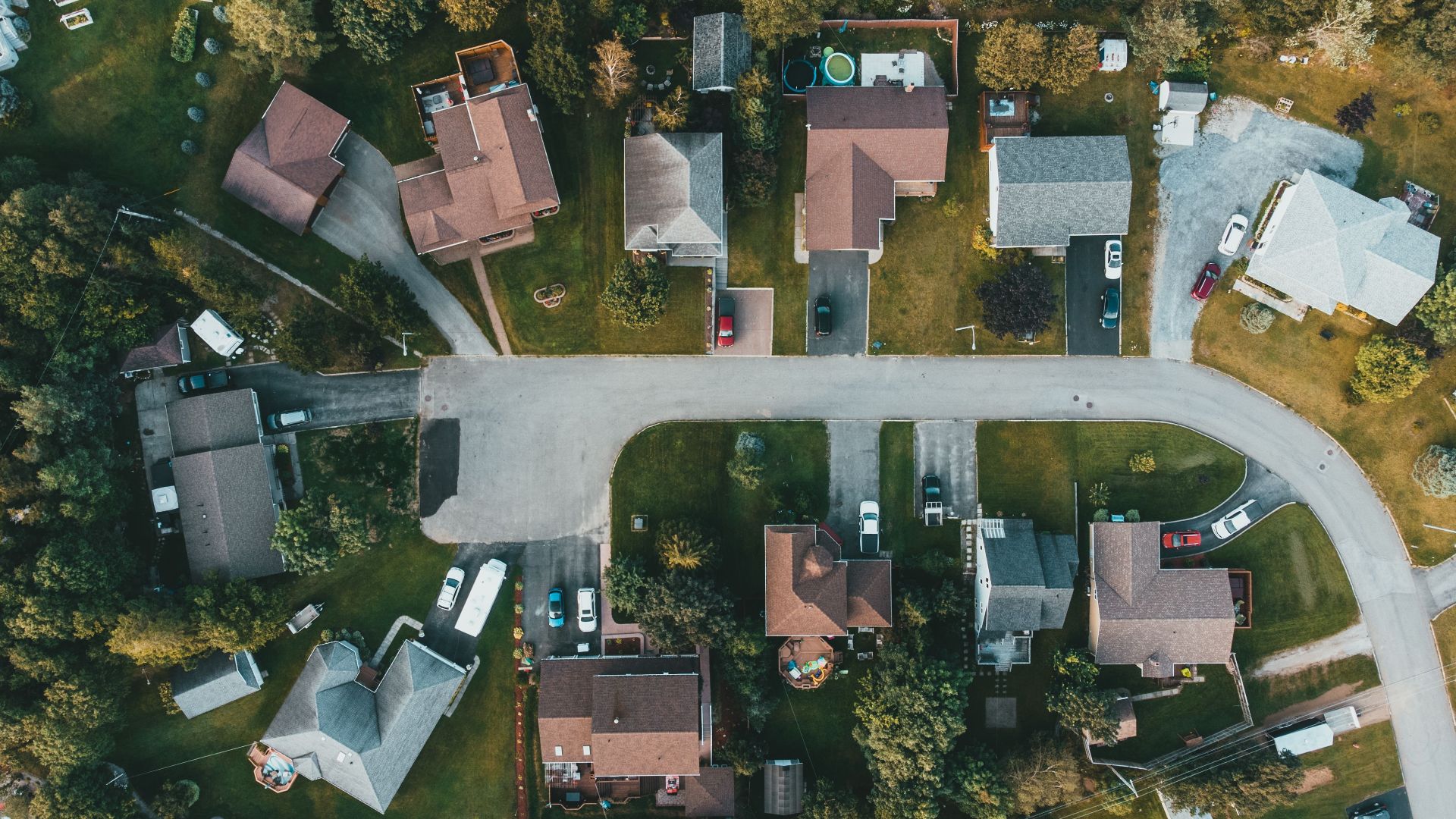 A top-down view of a suburban neighborhood showing houses, streets, and greenery.