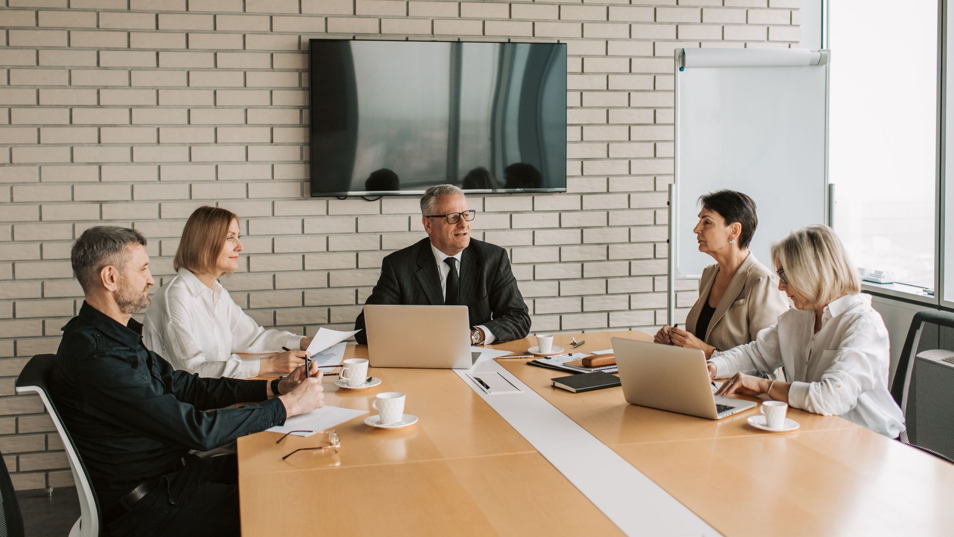 A professional team meeting with laptops and documents in a modern office.