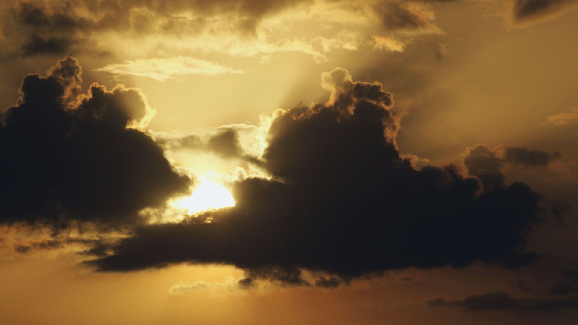 A stunning sunset with dramatic clouds and sun rays illuminating the sky.