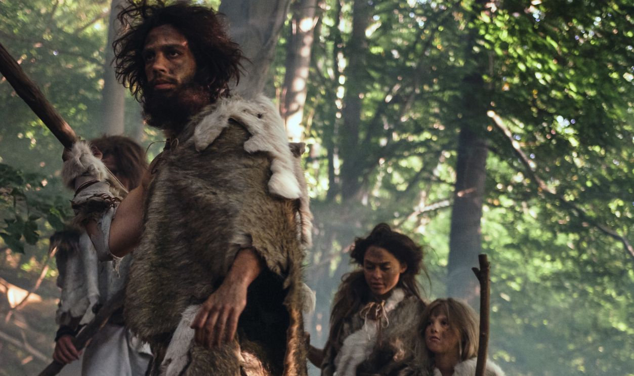 Tribe of Hunter-Gatherers Wearing Animal Skin Holding Stone Tipped Tools, Explore Prehistoric Forest in a Hunt for Animal Prey. Family Hunting in the Jungle or Migrating for Better Land